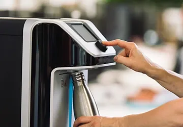Het vullen van een herbruikbare fles bij de waterkoeler